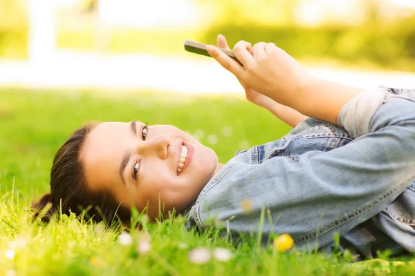 Smiling young girl lying on grass — Stock Photo, Image