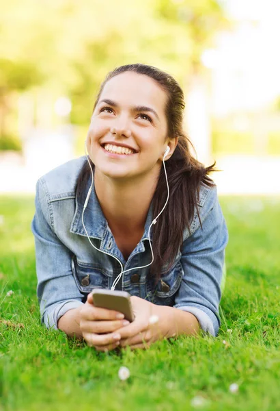 Lachende jong meisje met smartphone en koptelefoon — Stockfoto