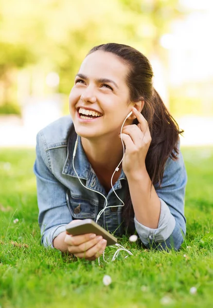 Śmiejąc się młoda dziewczyna z smartphone i słuchawki — Zdjęcie stockowe