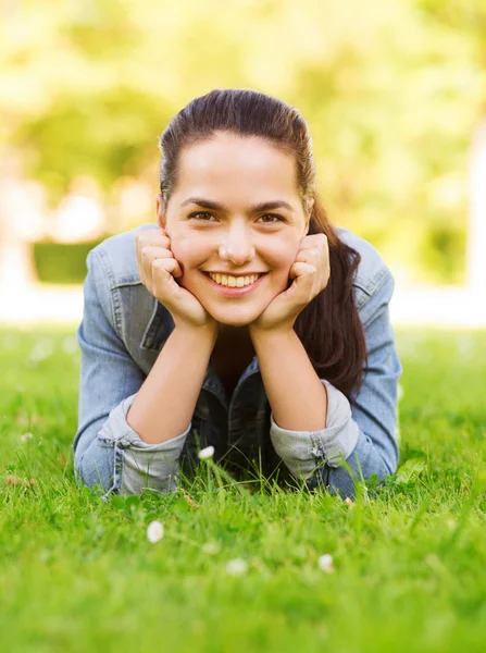 Sorridente giovane ragazza sdraiata sull'erba — Foto Stock