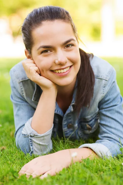 Sorridente giovane ragazza sdraiata sull'erba — Foto Stock