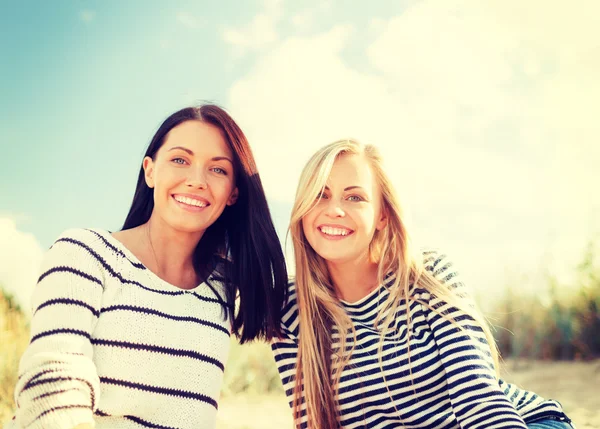Lächelnde Freundinnen, die Spaß am Strand haben — Stockfoto