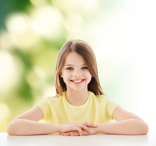 Schönes kleines Mädchen am Tisch sitzend — Stockfoto