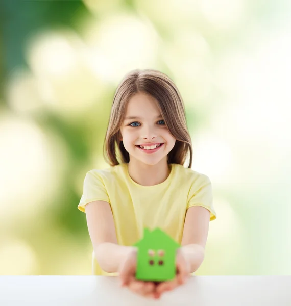 Beautiful little girl holding paper house cutout — Stock Photo, Image