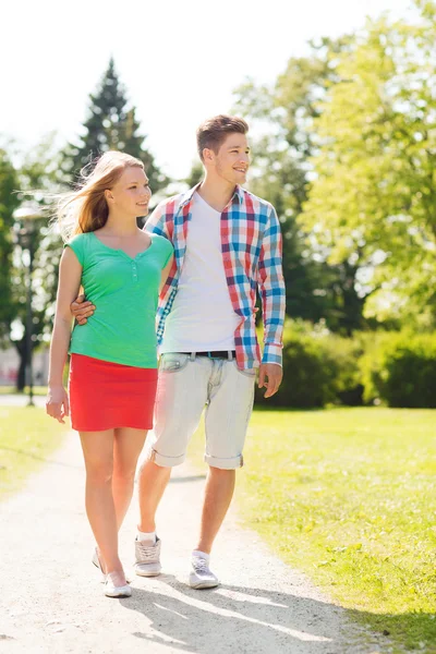 Couple souriant marchant dans le parc — Photo