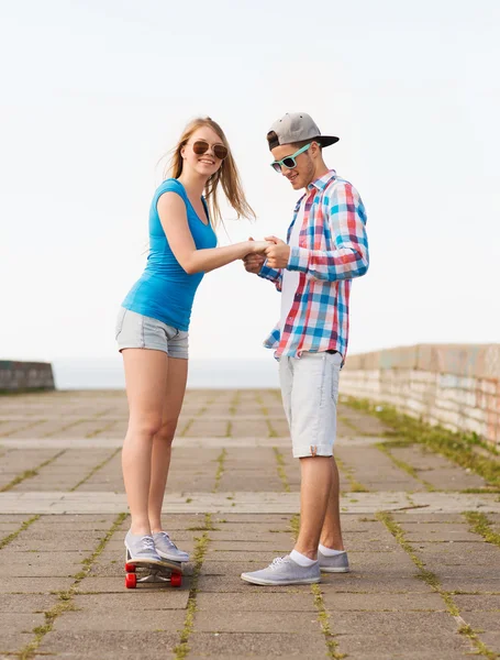 Couple souriant avec planche à roulettes en plein air — Photo