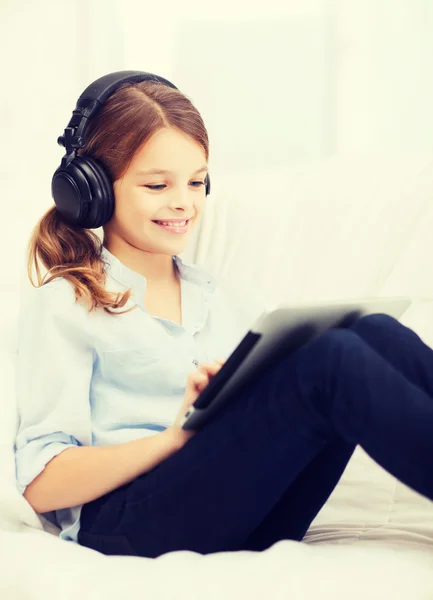 Fille avec tablette PC et écouteurs à la maison — Photo