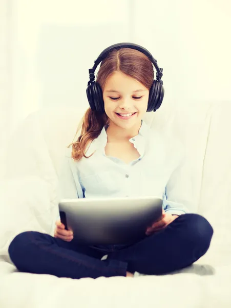 Chica con tablet PC y auriculares en casa —  Fotos de Stock