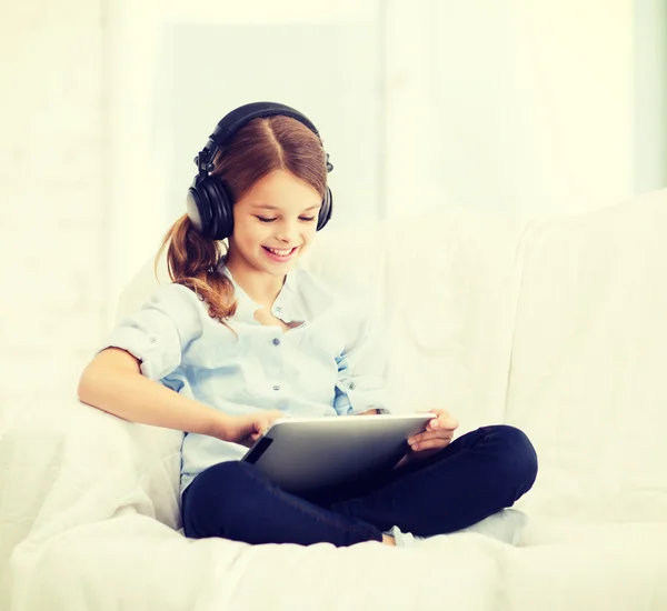 Chica con tablet PC y auriculares en casa — Foto de Stock