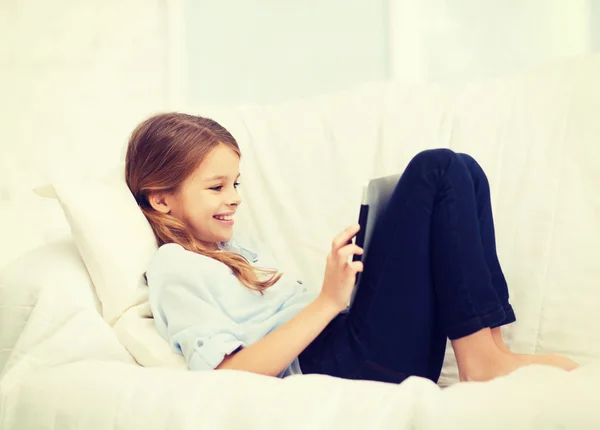 Усміхнена дівчина з планшетним комп'ютером вдома — стокове фото
