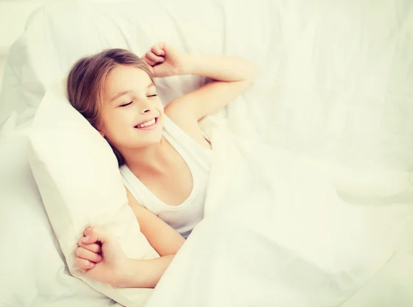 Усміхнена дівчинка дитина прокидається в ліжку вдома — стокове фото