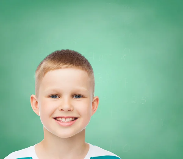 Lachende jongetje over groene bestuur achtergrond — Stockfoto