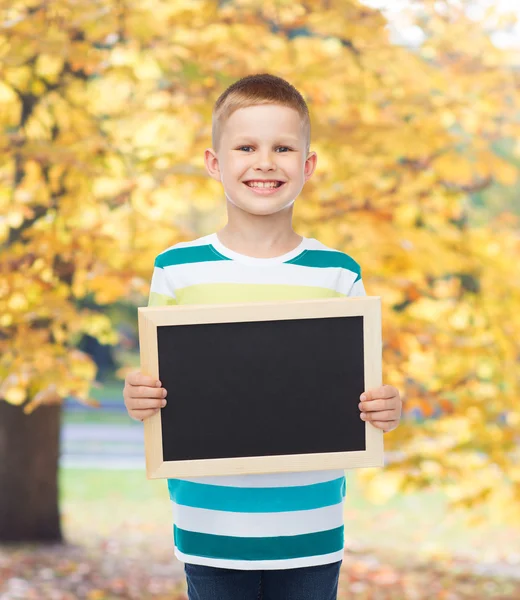 微笑着的小男孩抱着空白黑色的黑板 — 图库照片