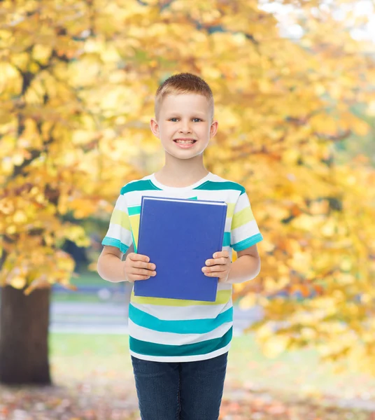 Leende liten student pojke med blå boken — Stockfoto