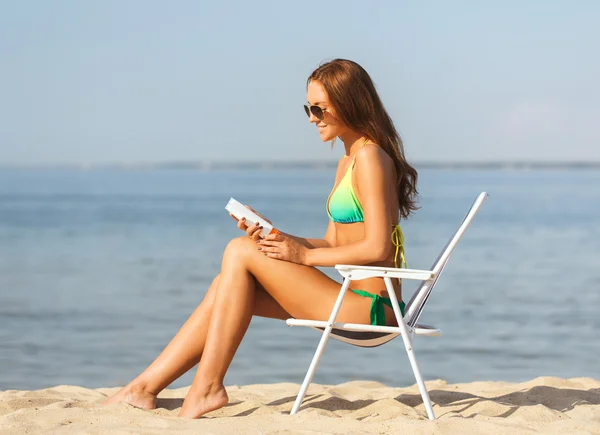 Sorrindo jovem mulher tomando banho de sol no salão na praia — Fotografia de Stock