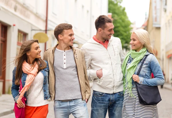 Groep lachende vrienden wandelen in de stad — Stockfoto