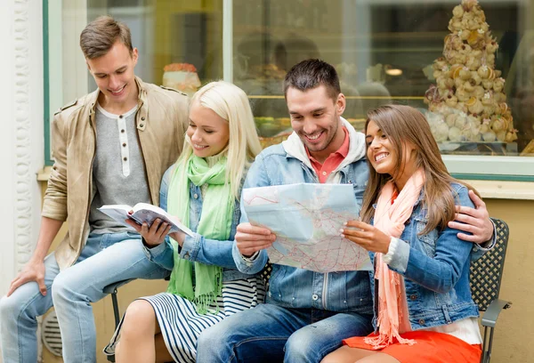 Group of friends with guide and map exploring town — Stock Photo, Image