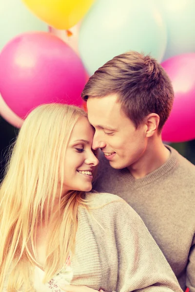 Пара с красочными воздушными шарами, целующимися в парке — стоковое фото