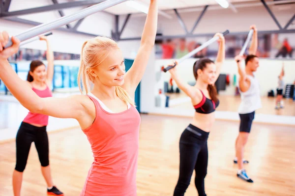 Groep mensen uit te werken met halters in gym — Stockfoto