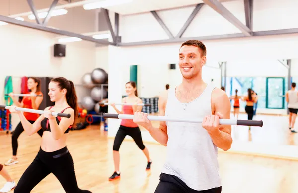 Group of smiling people working out with barbells — Stock Photo, Image