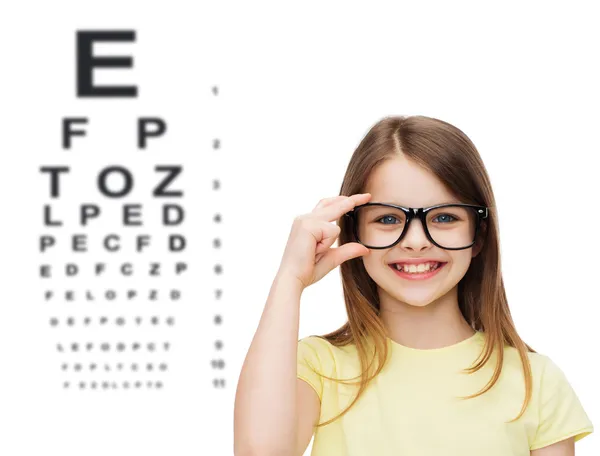 Smiling cute little girl in black eyeglasses — Stock Photo, Image