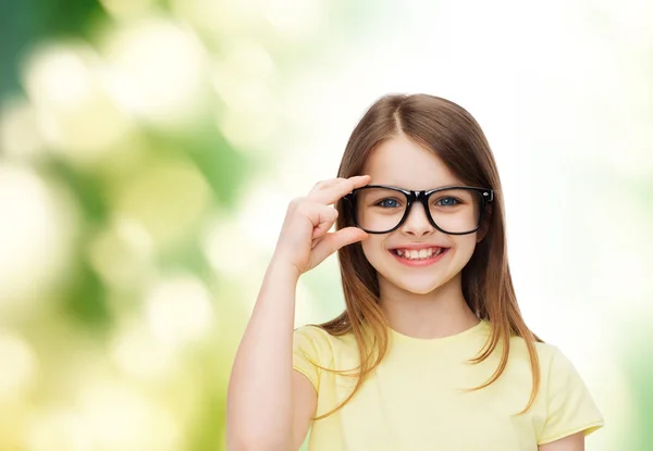 Smiling cute little girl in black eyeglasses — Stock Photo, Image