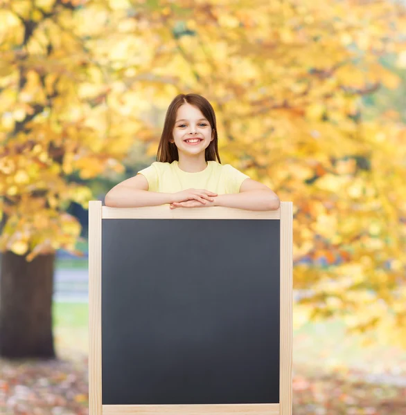 Šťastná holčička s prázdnou tabuli — Stock fotografie