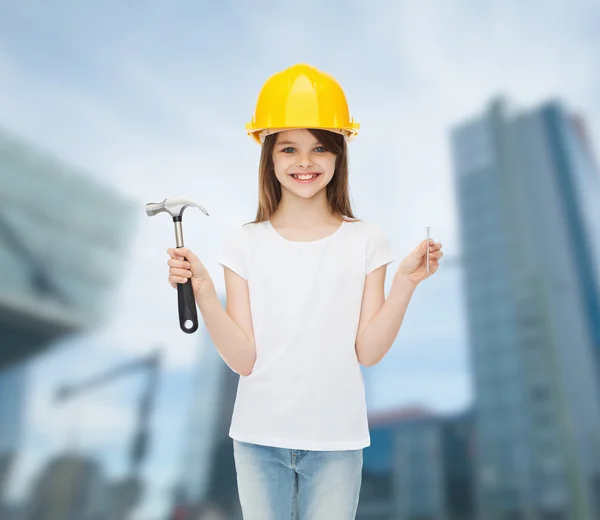 Smiling little girl in hardhat with hammer — Stock Photo, Image