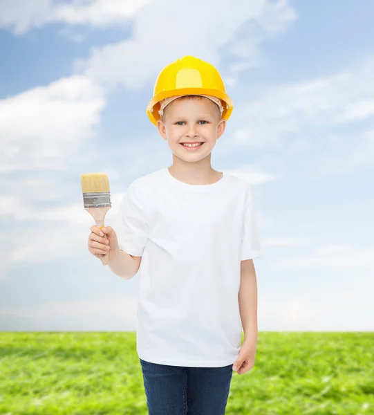 Smiling little boy in helmet with paint brush — Stock Photo, Image