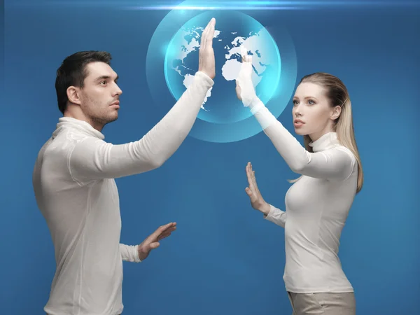 Homme et femme travaillant avec hologramme globe — Photo