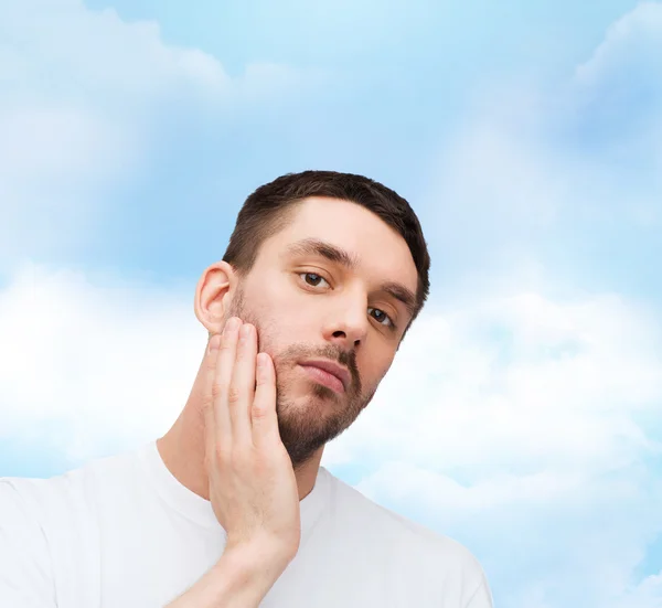 Beautiful calm man touching his face — Stock Photo, Image