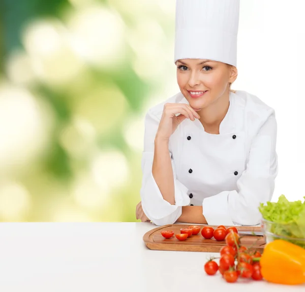 Lachende vrouwelijke chef-kok met groenten — Stockfoto