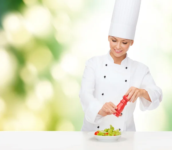 Lachende vrouwelijke chef-kok met de voorbereiding van salade — Stockfoto