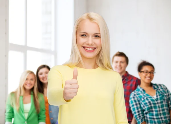 Menina sorridente em roupas casuais mostrando polegares para cima — Fotografia de Stock