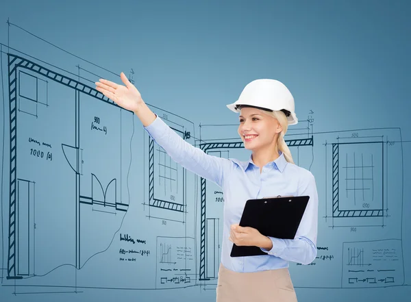 Smiling businesswoman in helmet with clipboard — Stock Photo, Image