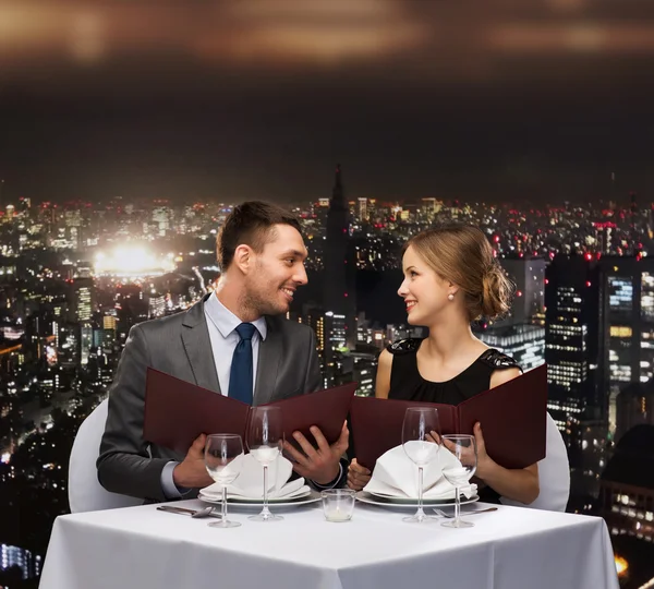 Usmívající se pár s menu v restauraci — Stock fotografie