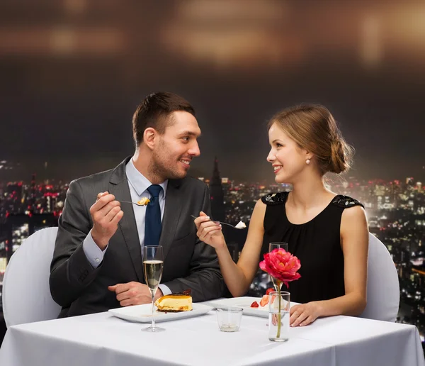 Smiling couple eating dessert at restaurant — Stock Photo, Image