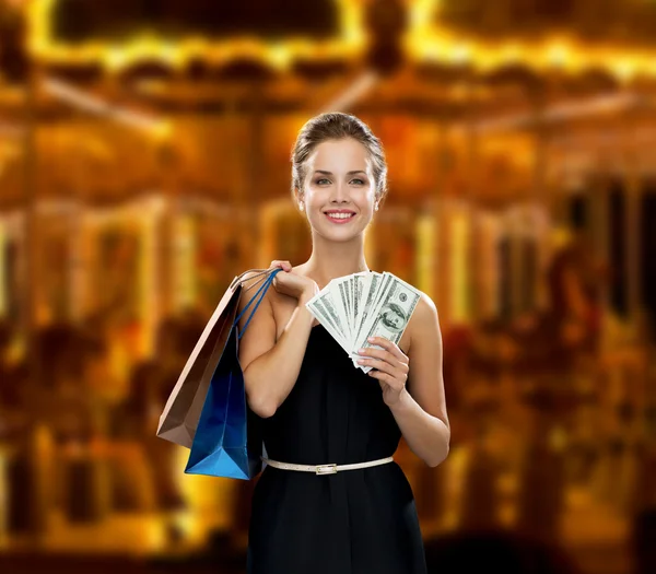 Mulher sorridente no vestido com sacos de compras — Fotografia de Stock