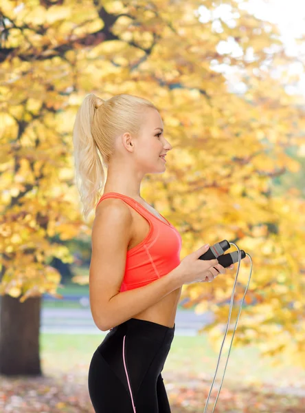 Lächelnde sportliche Frau mit Springseil — Stockfoto