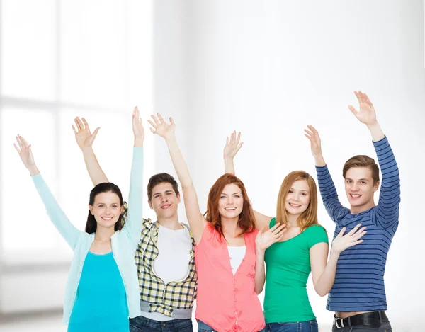 Grupp leende studenter viftande händer — Stockfoto