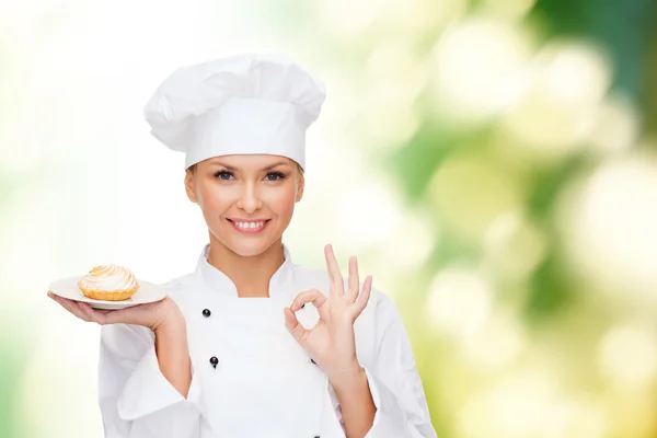 Улыбающаяся женщина-повар с тортом на тарелке Стоковое Фото