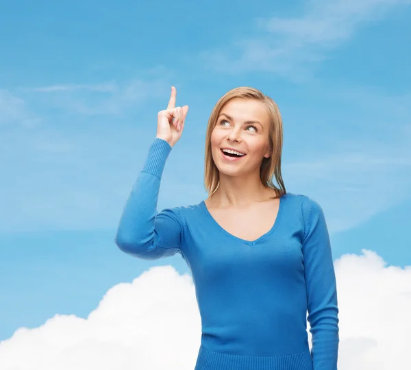 Lächelnde Frau zeigt mit dem Finger nach oben lizenzfreie Stockfotos