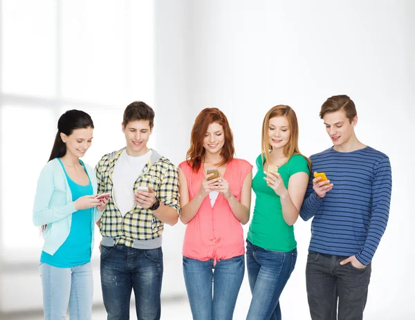 Lachende studenten met smartphones — Stockfoto