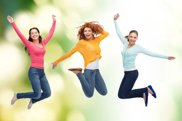 Grupo de mujeres jóvenes sonrientes saltando en el aire — Foto de Stock