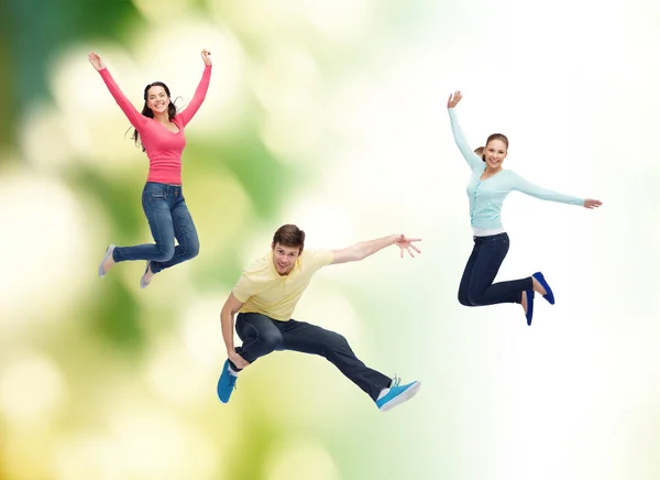 Group of smiling teenagers jumping in air — Stock Photo, Image