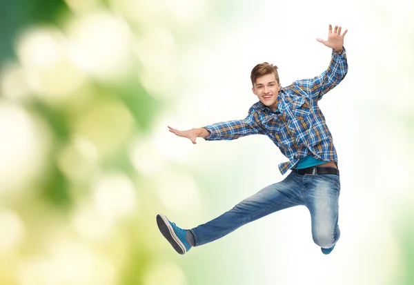 Lächelnder junger Mann springt in die Luft — Stockfoto