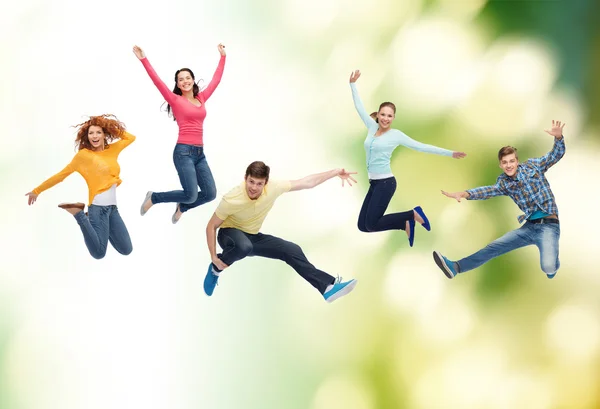 Groep van lachende tieners springen in de lucht — Stockfoto