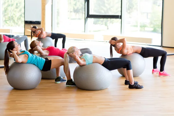 Grupo de mujeres sonrientes con bolas de ejercicio en el gimnasio — Foto de Stock