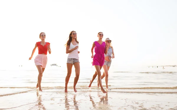 Grupo de mujeres sonrientes corriendo en la playa —  Fotos de Stock