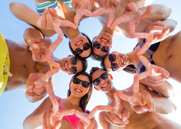 Amigos sonrientes en círculo en la playa de verano — Foto de Stock